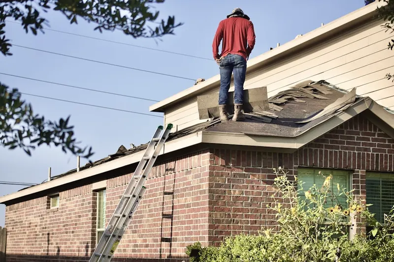Professional roofer working on a residential roof in Nine Row
